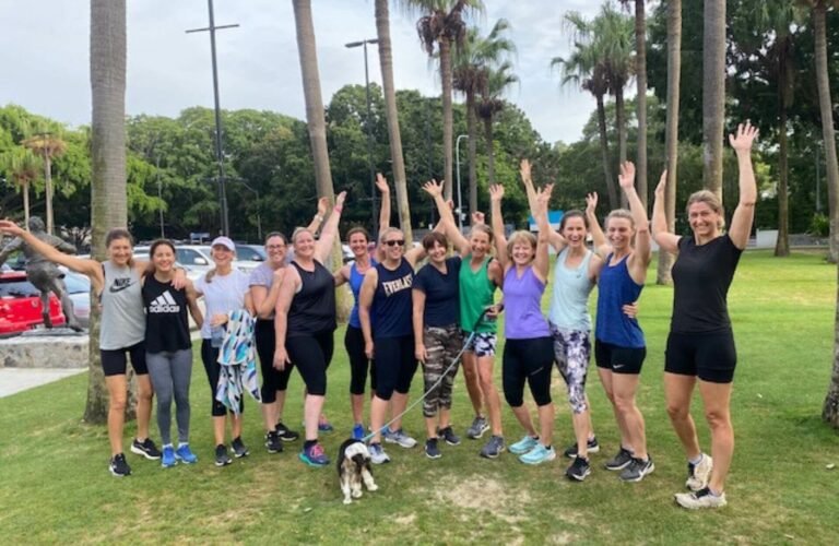 large group of women with arms in air, post training