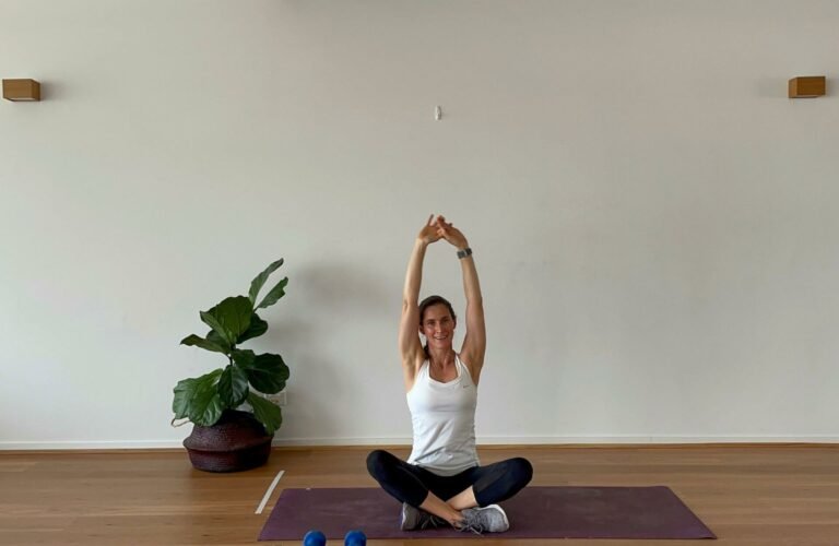 Em doing yoga seated yoga stretch with arms overhead