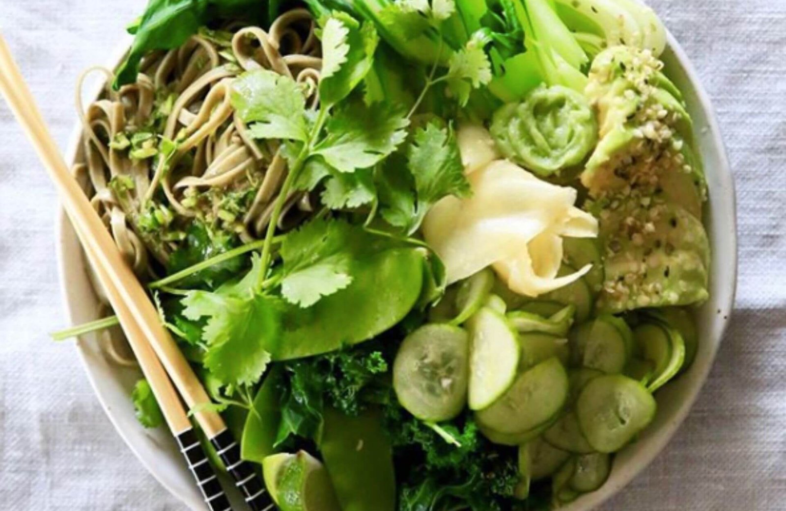 bowl of mixed green salad with chopsticks