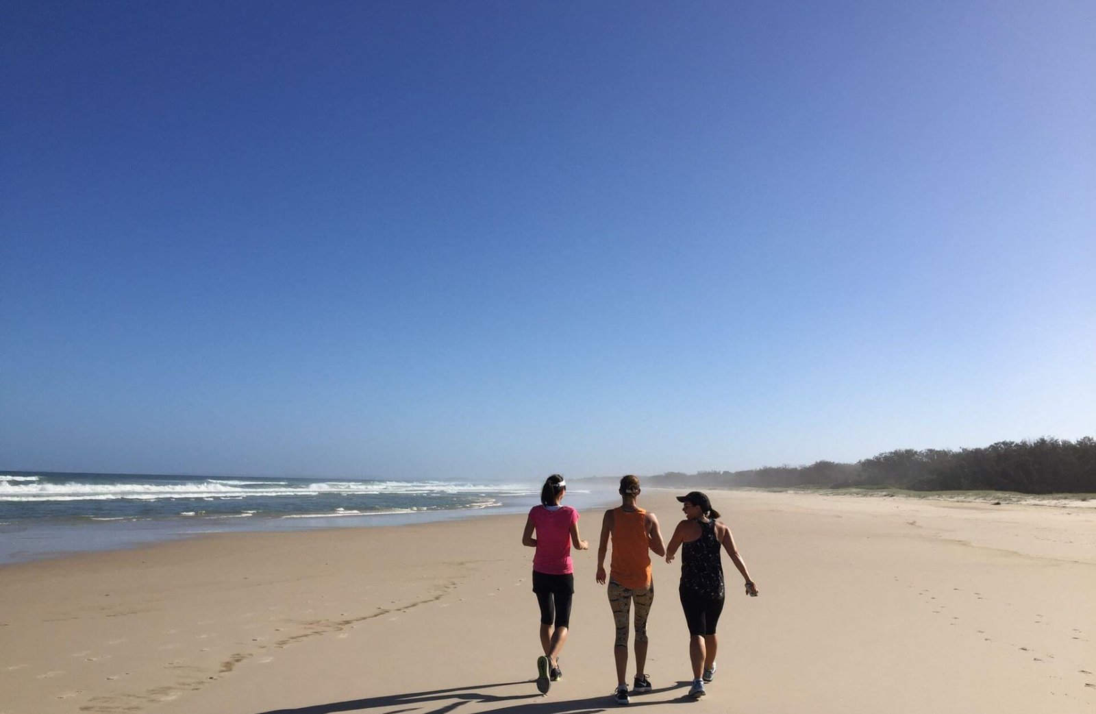 Anna and em with a friend walking on beach