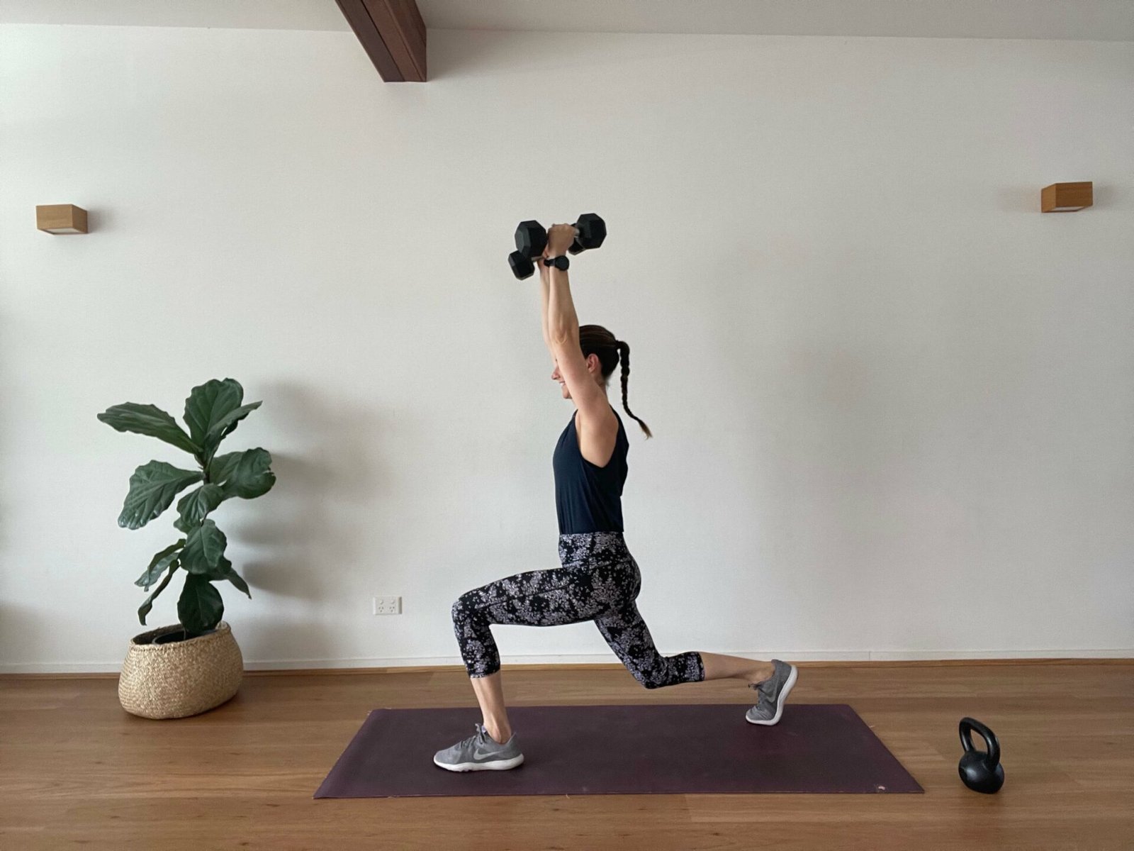 Em in studio in low lunge with overhead press