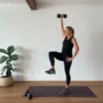 Anna in studio with high knee and single arm overhead press