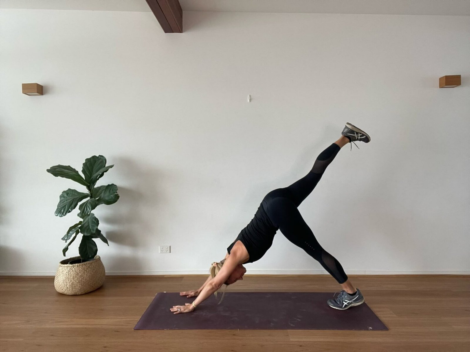 Anna in studio doing 3 legged dog yoga pose